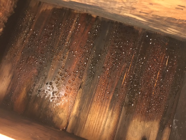 Water drops on underside of roof sheathing indicate a serious ventilation problem